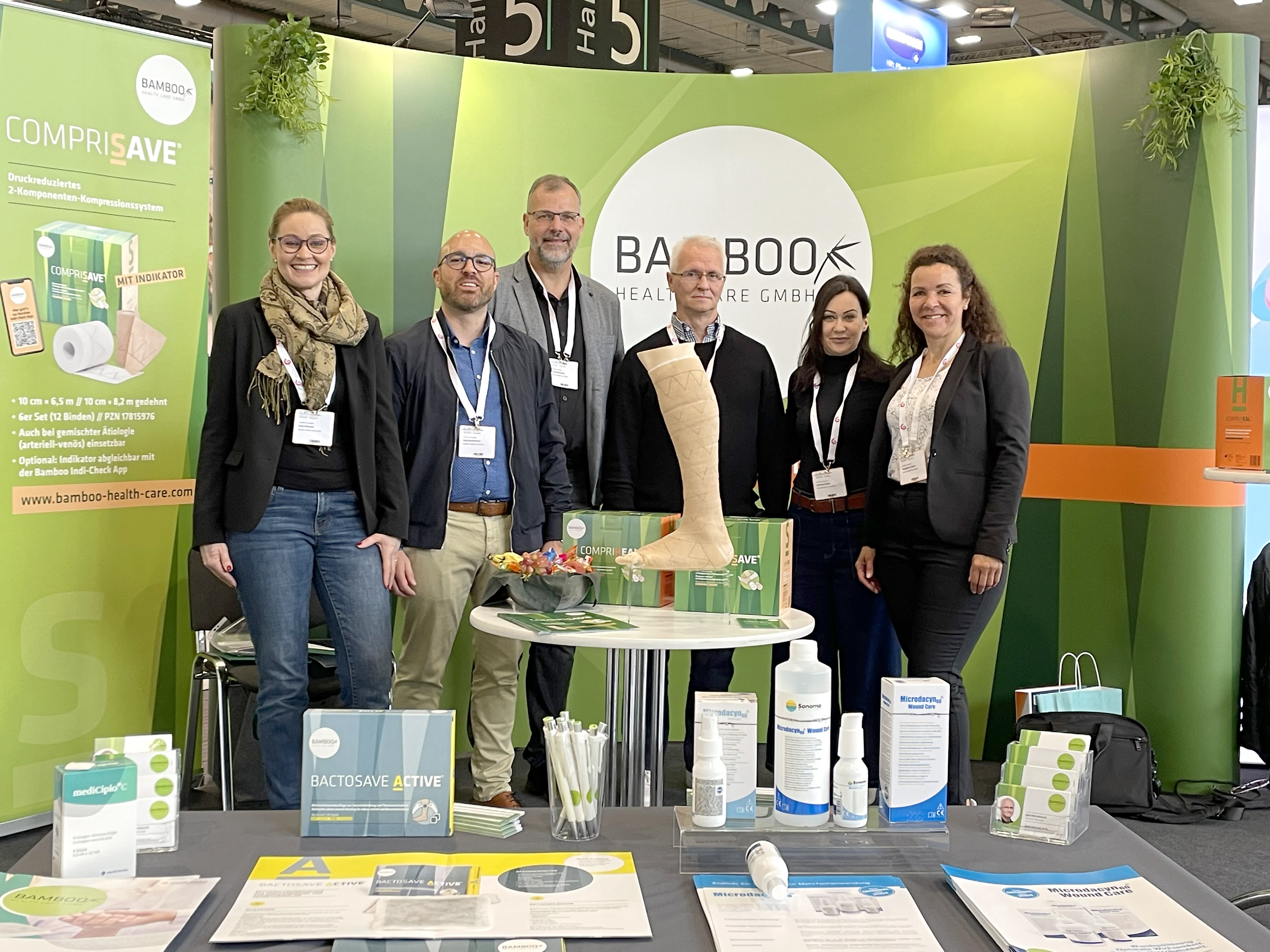 Unsere Außendienst Mitarbeiter Karin, Bernd, Joachim, Katharina und Jacqueline zusammen mit einem unserer Geschäftsführer Felix stehend an unserem Messestand mit einer Auswahl von Bamboo Produktansichtsexemplaren. | © Bamboo Health Care GmbH