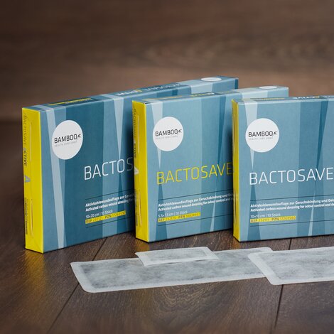 Die drei Verpackungsgrößen von BactoSave Active® stehend auf einem dunklen Holzboden. | © Bamboo Health Care GmbH